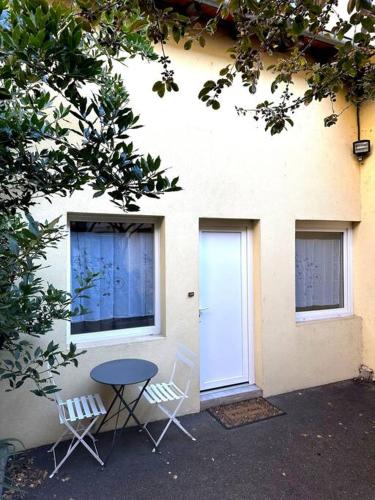 deux chaises et une table devant un bâtiment dans l'établissement Un petit cocon de tranquillité, à Mulhouse