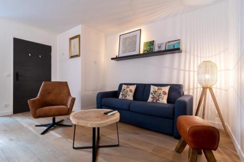un salon avec un canapé bleu et une chaise dans l'établissement Vieux Lille - Superbe appartement 2ch 5pers, à Lille