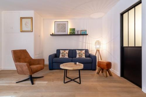 un salon avec un canapé bleu et une chaise dans l'établissement Vieux Lille - Superbe appartement 2ch 5pers, à Lille
