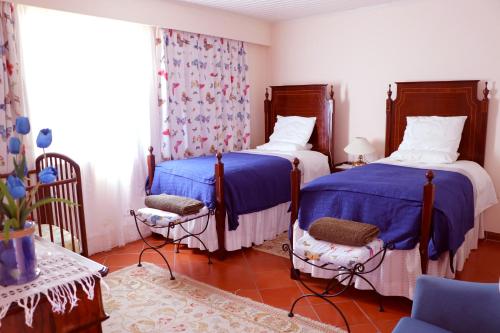 Casa Charmosa في فونشال: سريرين في غرفة باللون الأزرق والأبيض