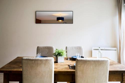 - une table à manger avec des chaises et un miroir dans l'établissement Vieux Lille - Superb apartment balcony parking!, à Lille