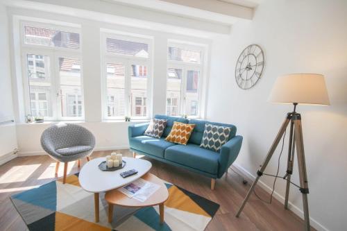 a living room with a blue couch and a table at Vieux Lille: bright, functional apartment in Lille