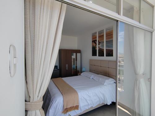 a bedroom with a bed and a sliding glass door at La Terraza Suite Chicama in Puerto Chicama
