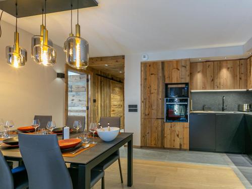 une cuisine et une salle à manger avec une table et des chaises dans l'établissement Appartement de standing avec Wi-Fi, garage, terrasse et accès direct aux pistes à Val-d'Isère - FR-1-694-348, à Val dʼIsère