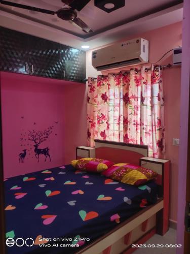 a bedroom with a bed with a purple and pink wall at UK Guest House in Tiruvallūr