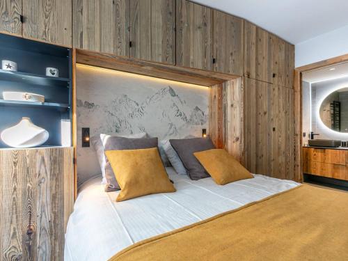 - une chambre avec un grand lit et des murs en bois dans l'établissement Appartement de standing avec Wi-Fi, garage, terrasse et accès direct aux pistes à Val-d'Isère - FR-1-694-348, à Val dʼIsère