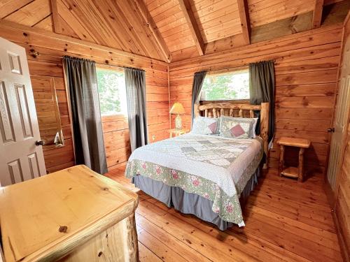 - une chambre avec un lit dans une cabane en bois dans l'établissement J Willy's Refuge, à Townsend