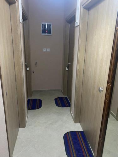 um corredor com duas portas e tapetes azuis no chão em Dimitris Rooms em Asvestokhórion