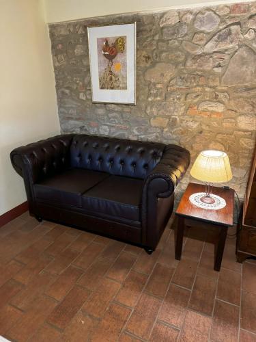 a black leather couch in a living room with a table at B&B Hotel La Piana in Borgo a Buggiano