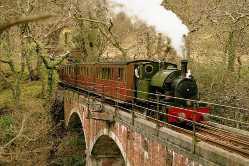 a train on a bridge with smoke coming at Caravan 309 Bryn Y Mor Beach Side Park in Tywyn