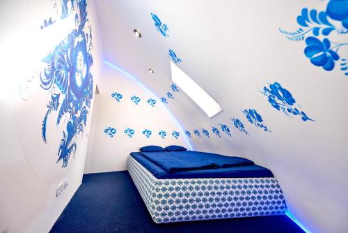 a room with a bed with blue flowers on the wall at Domeparty - лучшая локация для вечеринок in Petropavlovskaya Borshchagovka