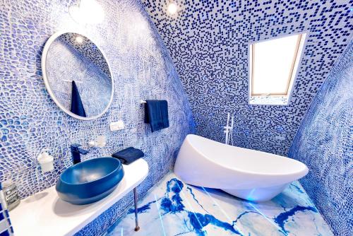 a blue bathroom with a sink and a mirror at Domeparty - лучшая локация для вечеринок in Petropavlovskaya Borshchagovka