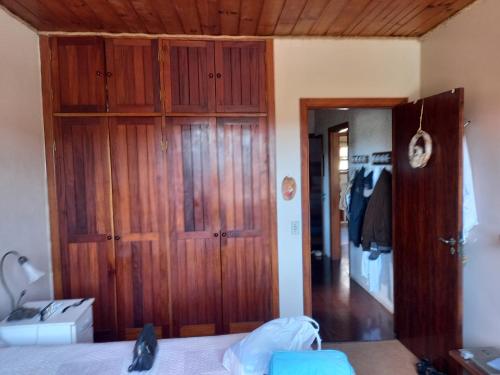 1 dormitorio con armario de madera y puerta en RESIDENCIA DOS MAFRA - Piso Térreo e RESIDENCIA DOS MAFRA - Piso Superior, en Campos do Jordão