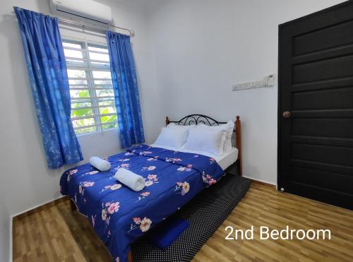 um quarto com uma cama com lençóis azuis e uma janela em Gemia Rumah Tamu - 3 bilik aircond - near nasi dagang Atas tol 