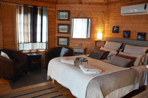 ein Schlafzimmer mit einem großen Bett in einem Holzzimmer in der Unterkunft Cottage romantique avec piscine privée au Vallon des Etoiles in Lussas