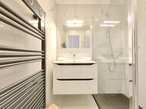 une salle de bain blanche avec un lavabo et une douche dans l'établissement Royal Lux seaview by Booking Guys, à Nice