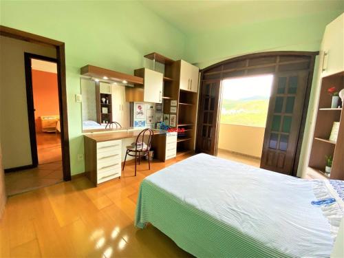 a bedroom with a large bed and a kitchen at Apartamento com vista panorâmica in João Monlevade