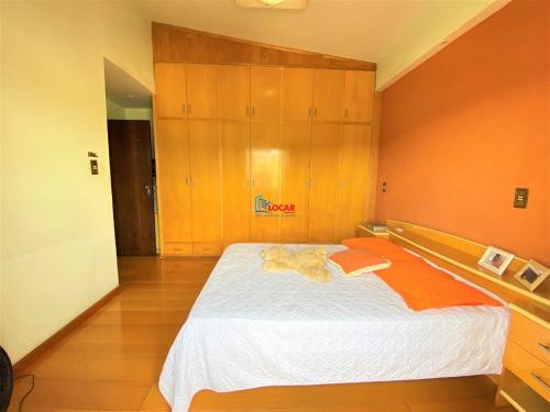 a bedroom with a large bed with wooden cabinets at Apartamento com vista panorâmica in João Monlevade