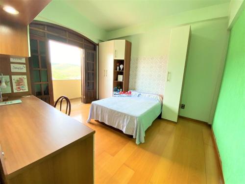 een slaapkamer met een bed in een kamer met een keuken bij Apartamento com vista panorâmica in João Monlevade
