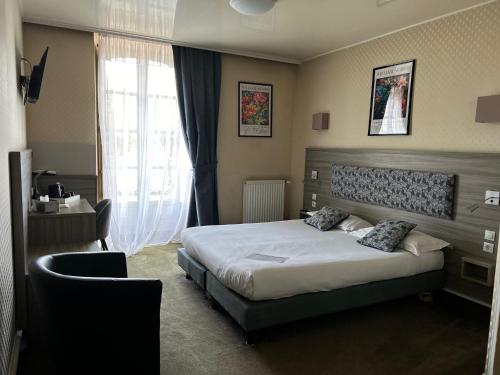 a hotel room with a bed and a window at Cit'Hotel le Challonge in Dinan