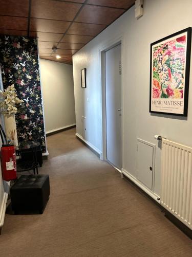 a hallway of an office with a painting on the wall at Cit'Hotel le Challonge in Dinan