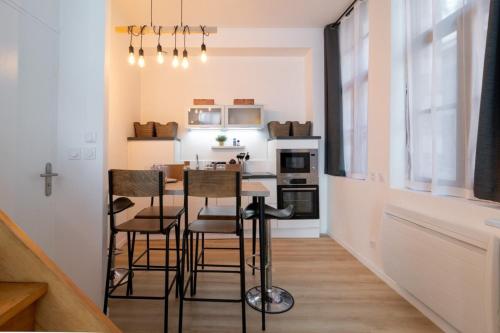 une petite cuisine avec une table et des chaises dans une pièce dans l'établissement Unique 3 bed house in Old Lille!, à Lille