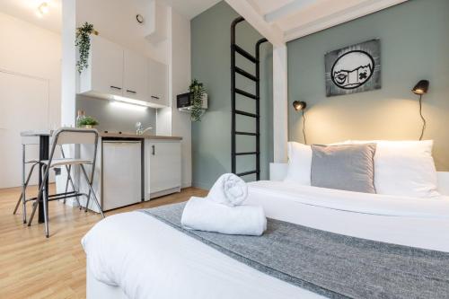 une chambre avec un grand lit blanc et une cuisine dans l'établissement Lille Saint Maurice - Nice and functional studio, à Lille