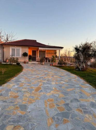 un vialetto in pietra di fronte a una casa di Villa Nikol a Tirana