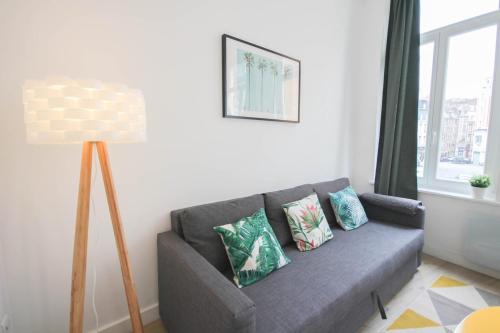 uma sala de estar com um sofá cinzento e um candeeiro em Lille Gares - 50m2 apartment! em Lille