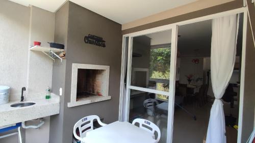 a bathroom with a sink and a shower with a fireplace at Apartamento em Bombinhas Próximo ao centro e Passarela do Ribeiro in Bombinhas