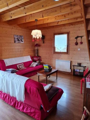 - un salon avec deux canapés rouges dans une cabine dans l'établissement Chalet, Murat (nouveau logement), à Murat