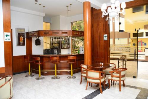 GLORIA PLAZA HOTEL في تشيكلايو: بار في مطعم مع طاولة وكراسي