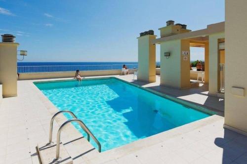 une piscine avec l'océan en arrière-plan dans l'établissement Royal Lux seaview by Booking Guys, à Nice