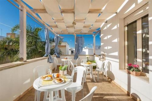 d'un balcon avec des tables et des chaises et une vue sur l'océan. dans l'établissement B&B Albatro, à Taviano
