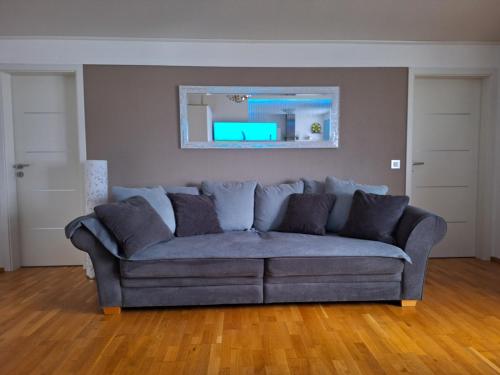 a blue couch in a living room with a mirror at modern und gemütlich in Linden