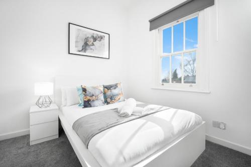 Habitación blanca con cama y ventana en Fabulous Apartment Overlooking Canal - Parking - Perry Barr - WIFI - Netflix - 3PB, en Birmingham