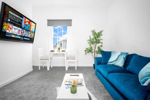 uma sala de estar com um sofá azul e uma mesa em Fabulous Apartment Overlooking Canal - Parking - Perry Barr - WIFI - Netflix - 3PB em Birmingham