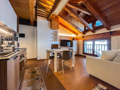 uma cozinha e sala de estar com uma mesa e um sofá em Maison Poluc hotel apartments em Champoluc