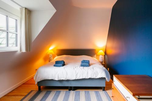 a bedroom with a bed with two blue towels on it at Villa Westland in Koksijde