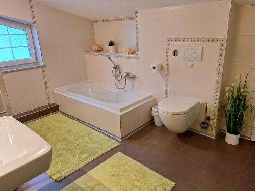 a bathroom with a tub and a toilet and a sink at modern und gemütlich in Linden