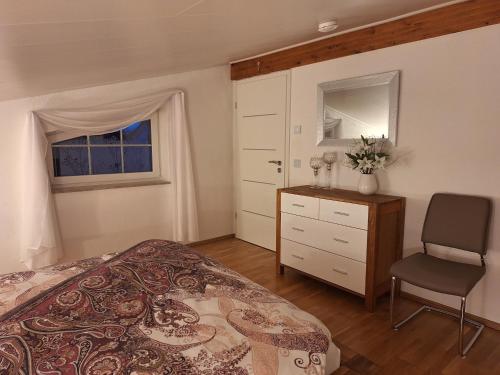 - une chambre avec un lit, une chaise et une fenêtre dans l'établissement modern und gemütlich, à Linden