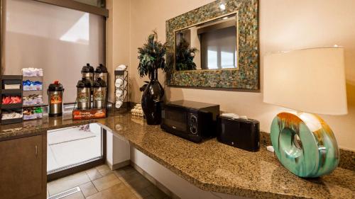 a hotel room counter with a microwave and a mirror at Best Western Plus Kelly Inn in Saint Cloud