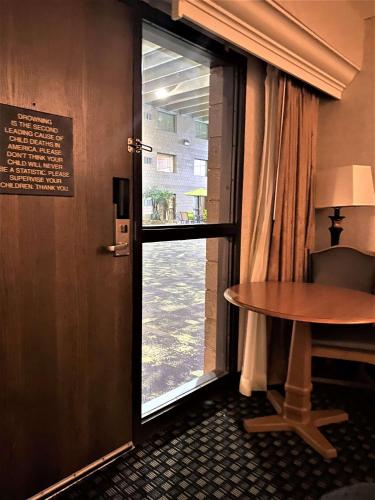 a door to a room with a table and a window at Best Western Plus Kelly Inn in Saint Cloud