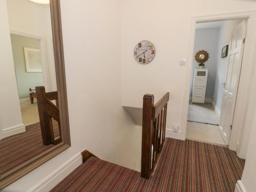 a hallway with a mirror and a stairway at Swn Yr Afon in Tywyn