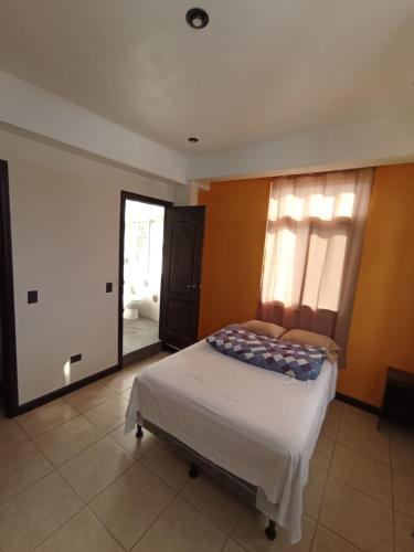 a bedroom with a bed and a large window at Hotel Posada Lucia in San Juan La Laguna