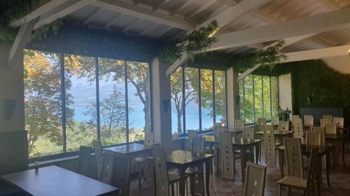 un restaurant avec des tables et des chaises et de grandes fenêtres dans l'établissement LE COMPTOIR, à Sainte-Croix-de-Verdon