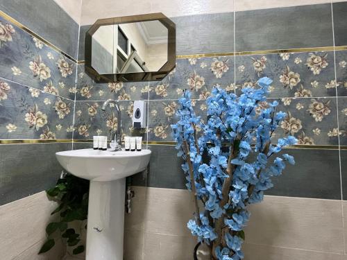 a bathroom with a sink and blue flowers at Panorama 3 Pyramids View Inn in Giza