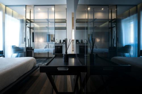 a bedroom with a bed and a glass table at HOTIDAY Room Collection - Olbia Wallure in Olbia