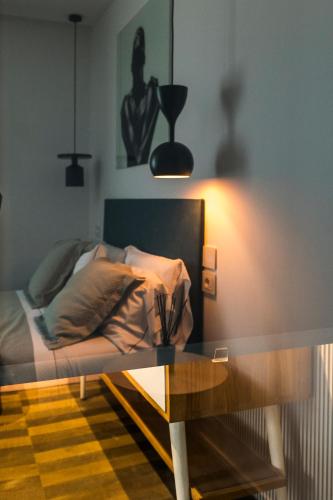 a bedroom with a bed with a table and a lamp at HOTIDAY Room Collection - Olbia Wallure in Olbia