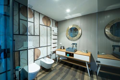 a bathroom with a sink toilet and a mirror at HOTIDAY Room Collection - Olbia Wallure in Olbia